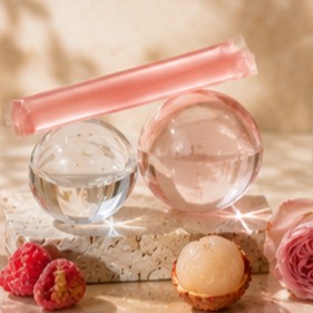 Glow jelly stick balanced on glass spheres beside a rose in a bud vase