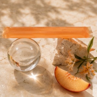 Move jelly stick balanced across a glass sphere and stone with blossom